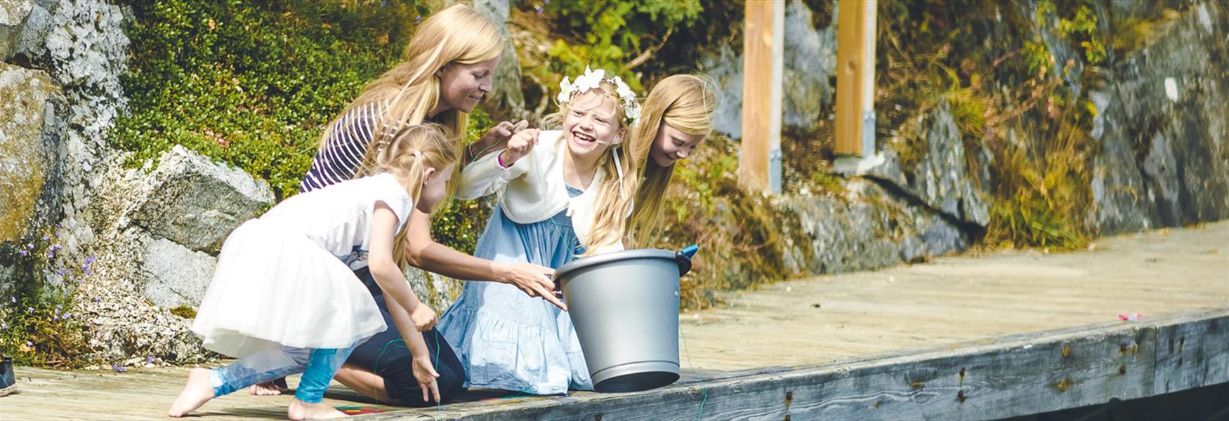 lady with 3 girls and a bucket on a wharf