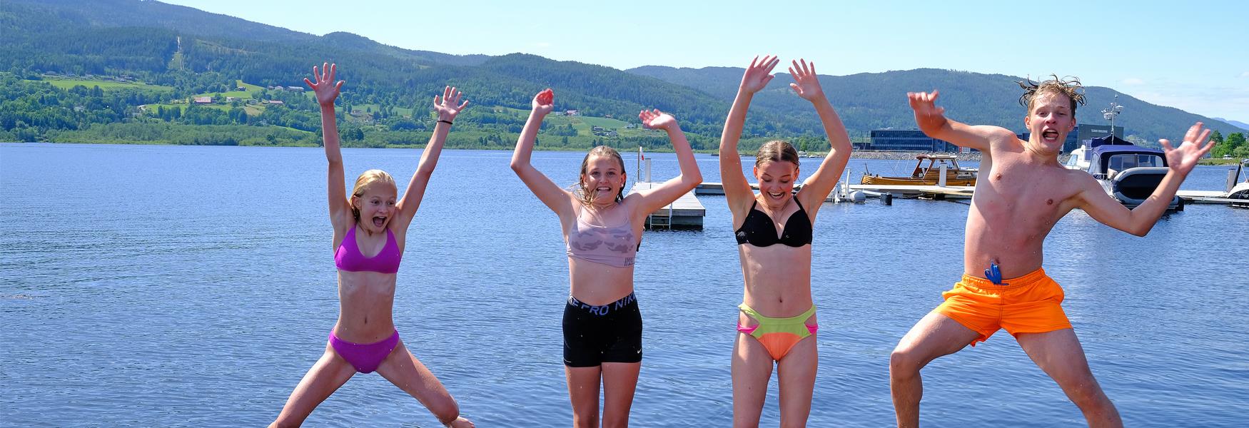children in swimwear jumping and frolicking