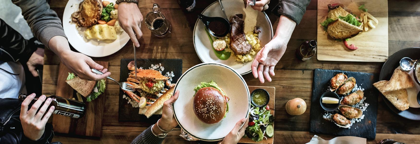 many dishes on a table and people sitting around the table eating