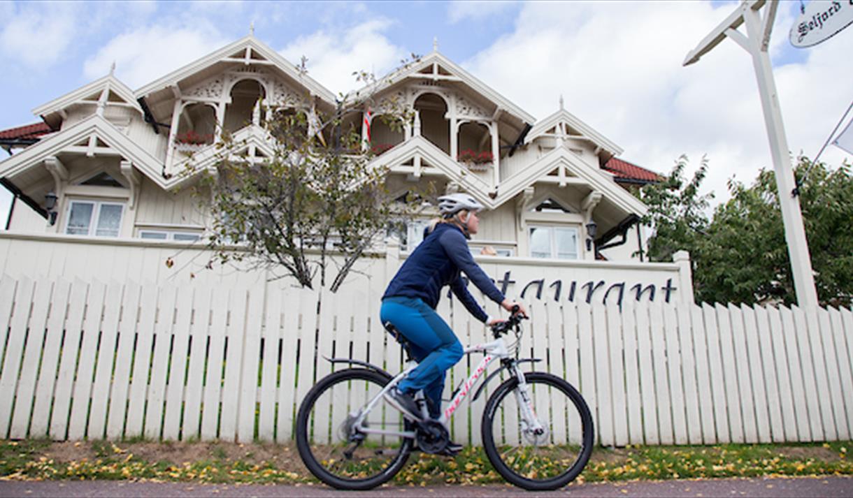A cyclist rides past a house in Seljord.