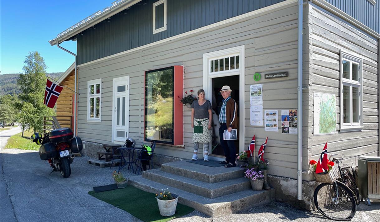 man and woman in front of the entrance to Holm Landhandel