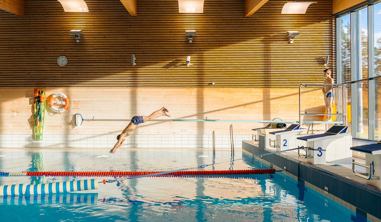Boy dives into the pool.