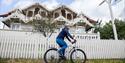 A cyclist rides past a house in Seljord.