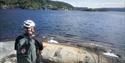 man sitting on a rock and looking at the water at Slerva swimming pool