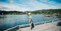 A little boy is standing on the dock at the experience trail Vasseventyret in Haukeli.
