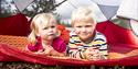 little boy and girl are lying in a tents on a hike to the treetop in Bø