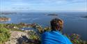 hiker looks out over the water from Vardås
