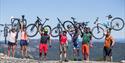 group of cyclists holding their bikes in the air