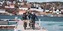 Cyclists riding along a pier